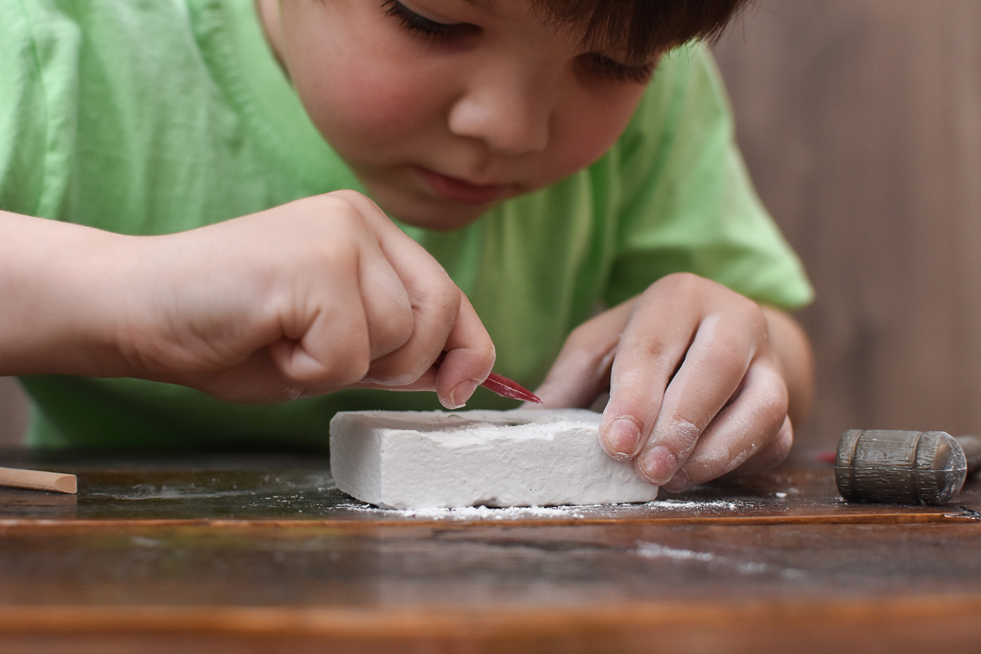 Bambino che scava con un kit archeologico